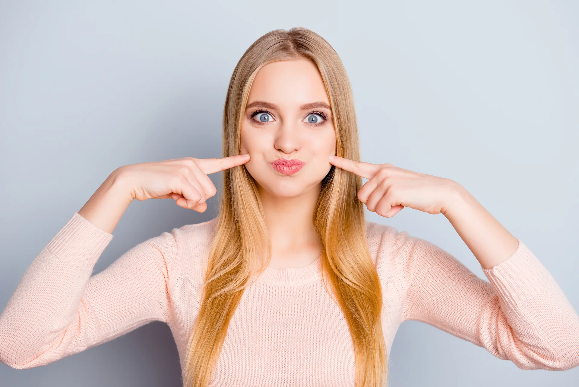 a young woman pointing her chubby cheeks||
