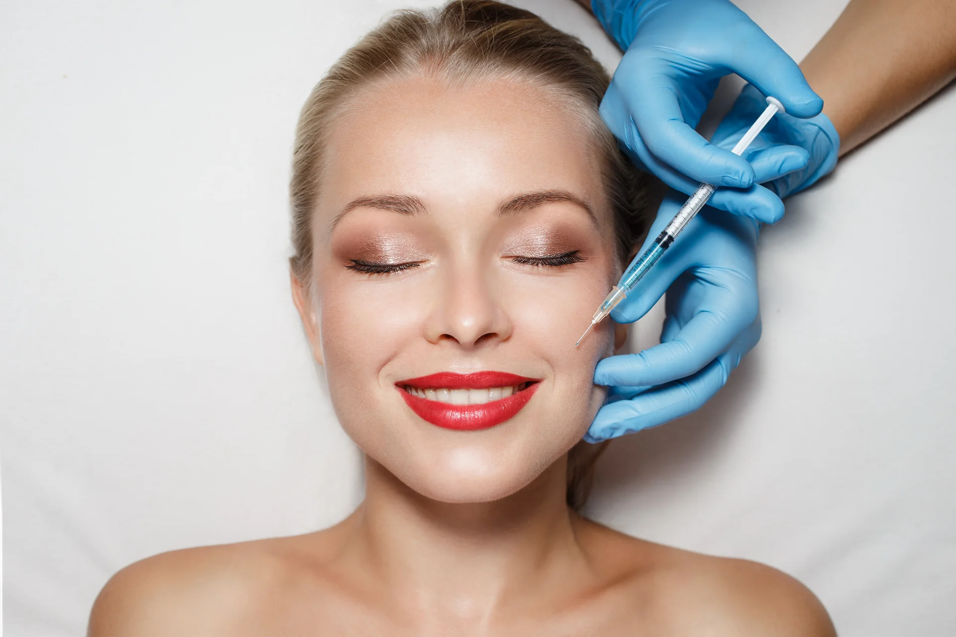 A woman getting cheek filler injection||||