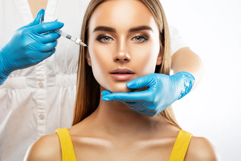 Gloved practitioner injecting dermal filler into a woman's cheek