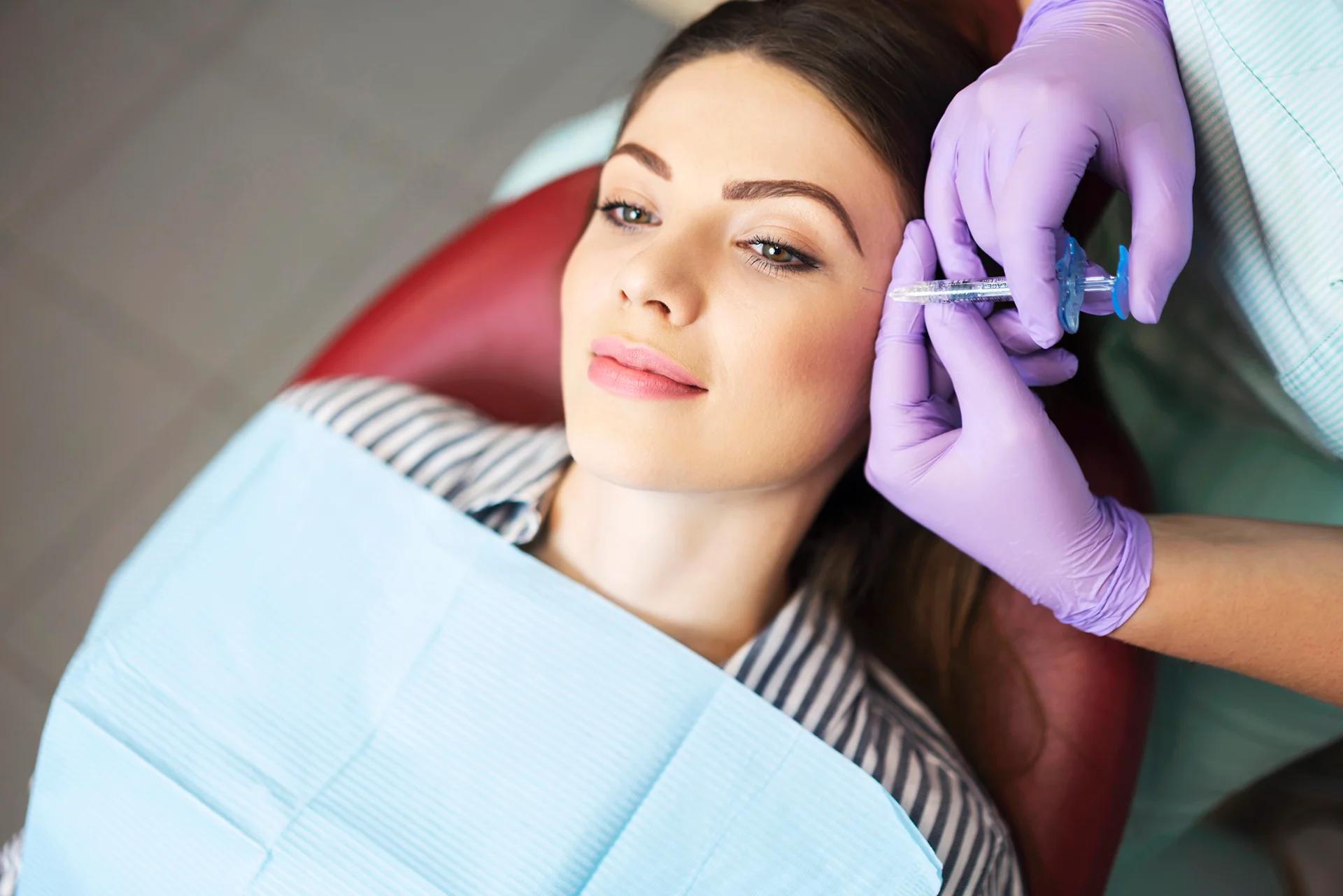 woman receives cheek filler injections at a beauty clinic