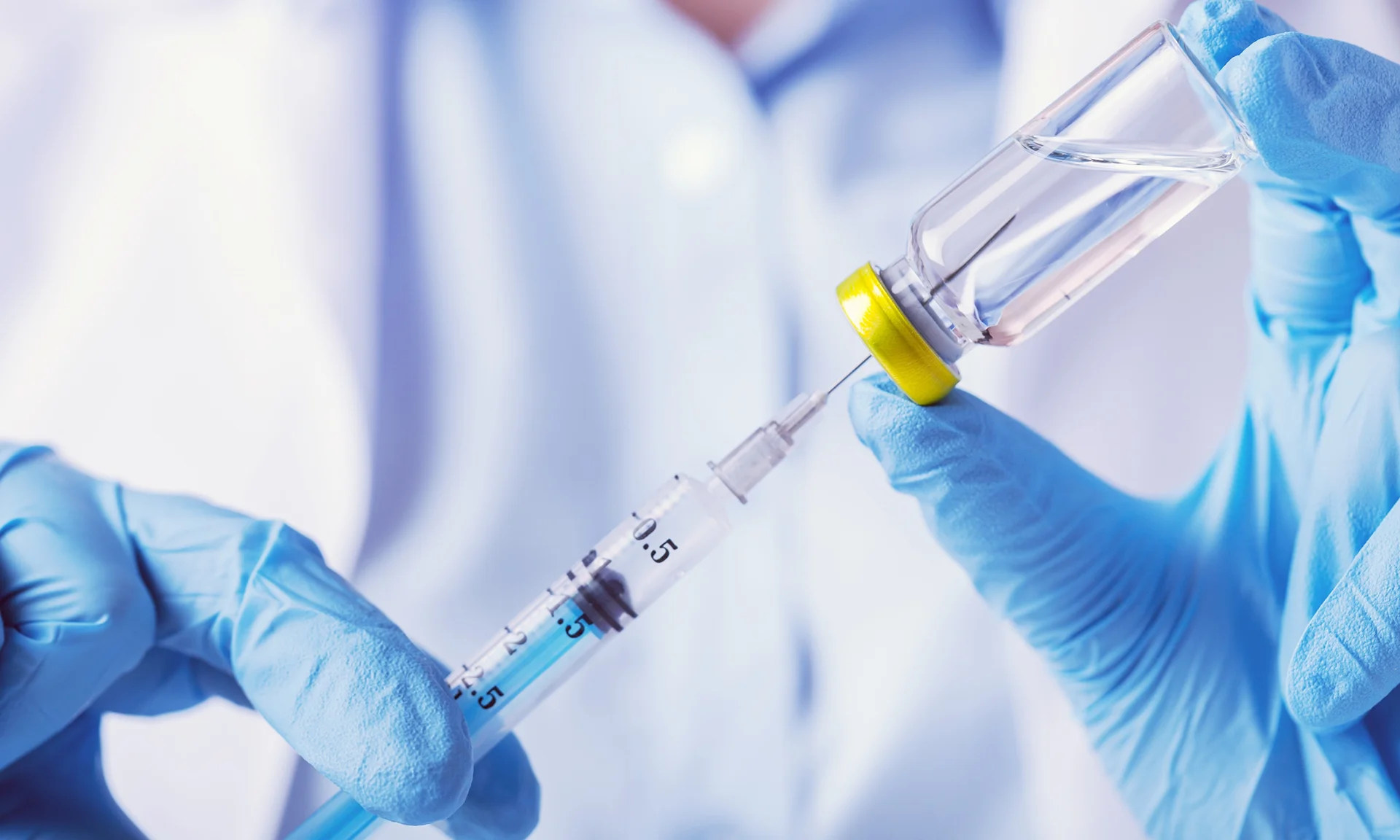 Medical provider holding syringe and vial||