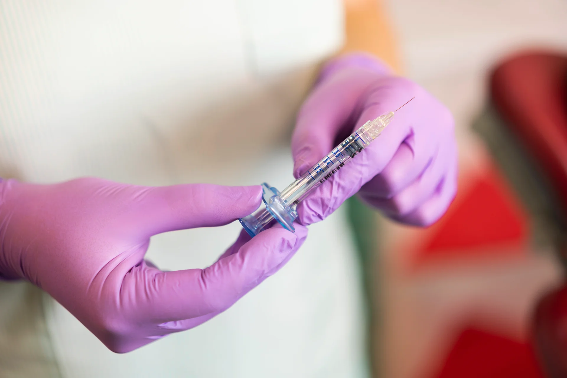 aesthetician holding a syringe filled with hyaluronic acid dermal filler|Dr. Lanna holds a syringe filled with hyaluronic acid dermal filler