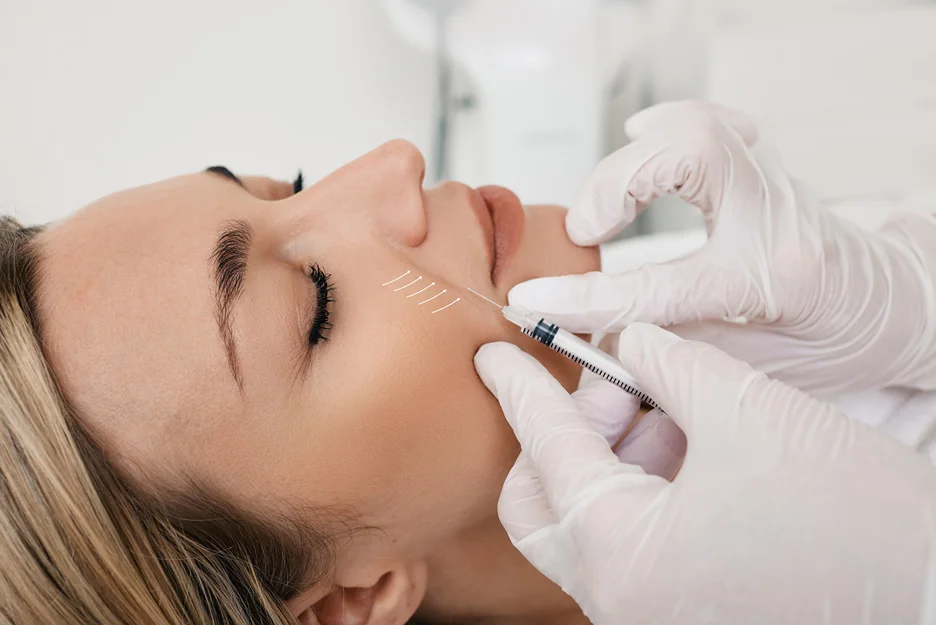 a woman receives dermal fillers treatment