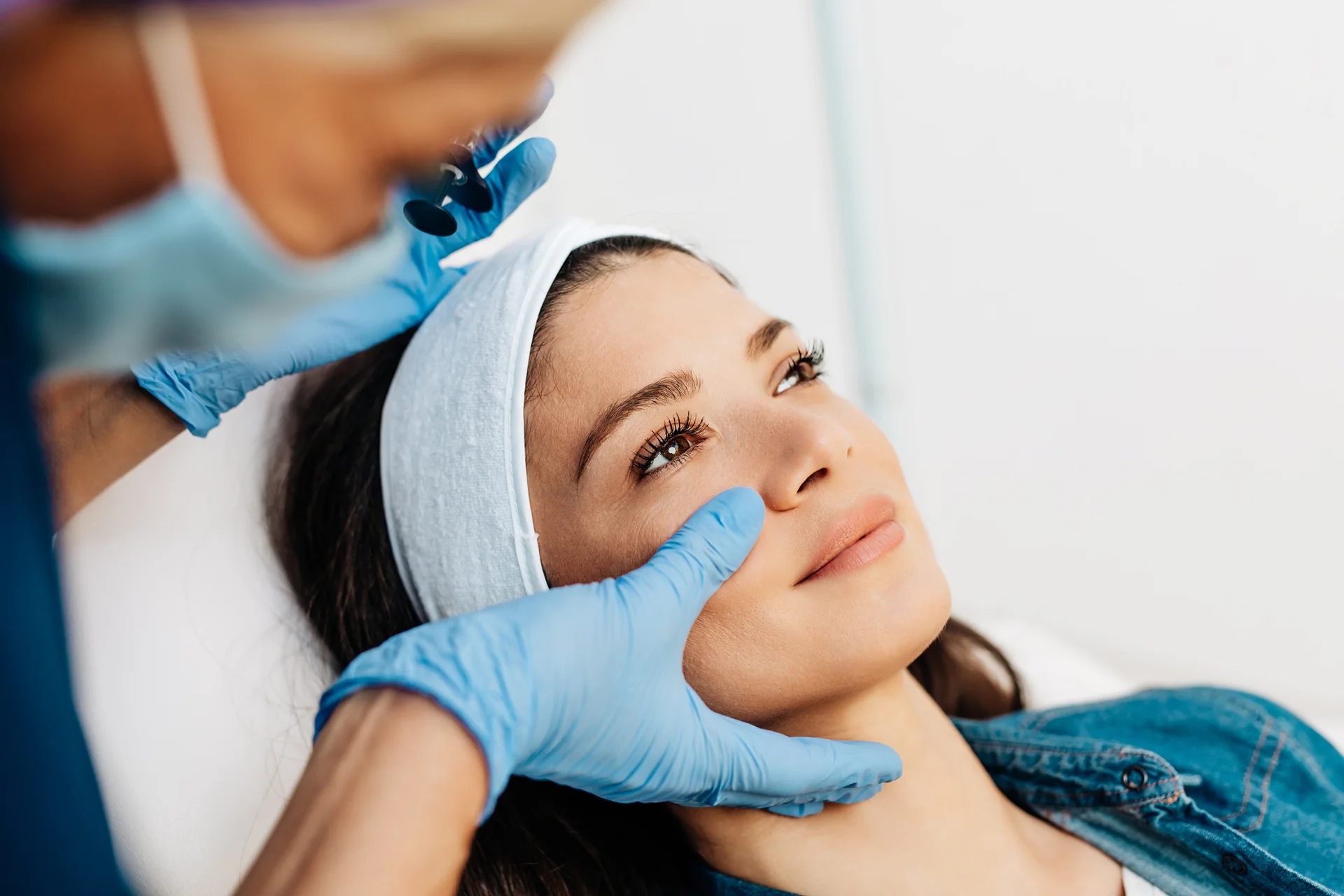 a medical provider checks the patient's cheek before cheek filler procedure||