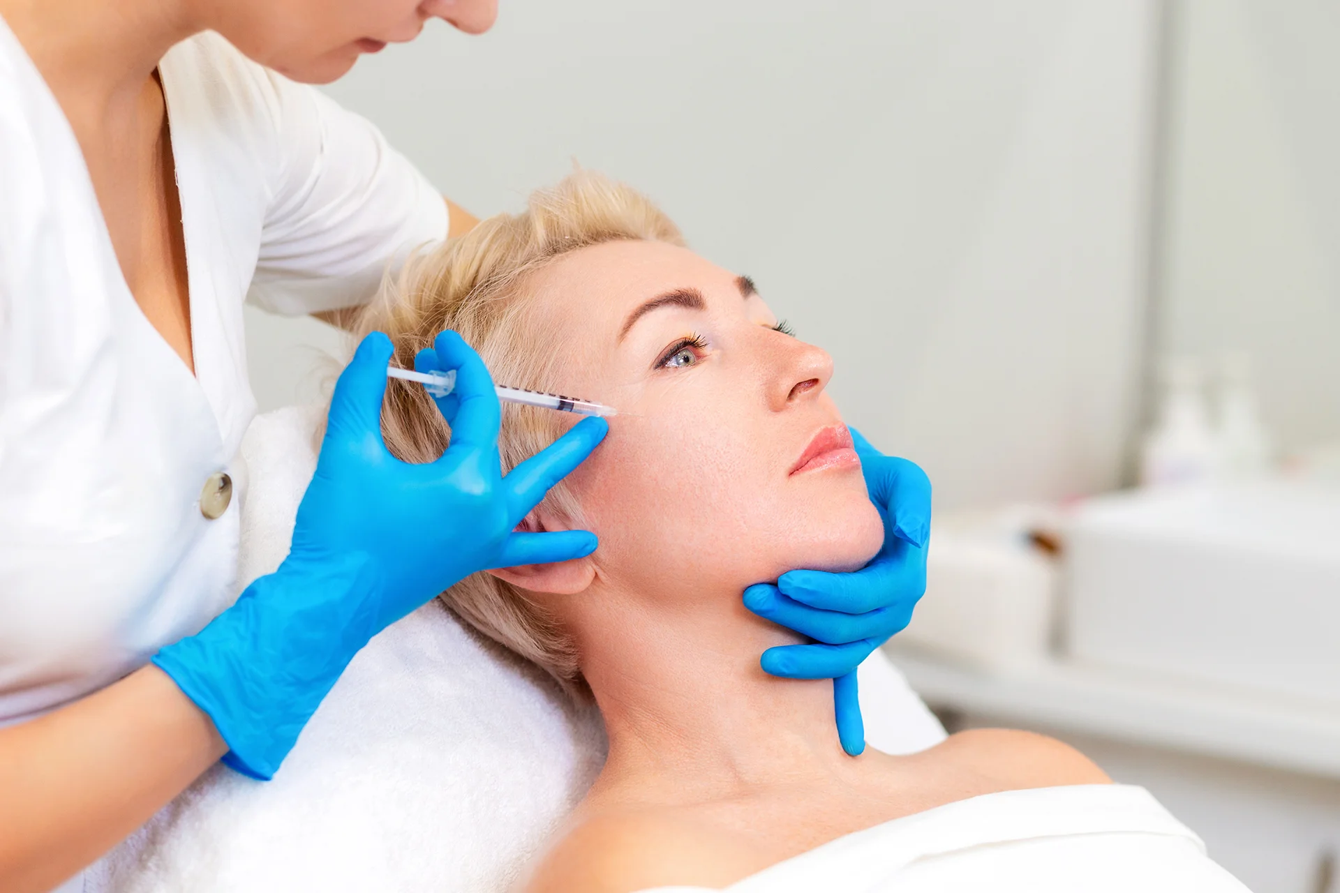 a woman getting cheek filler treatment||