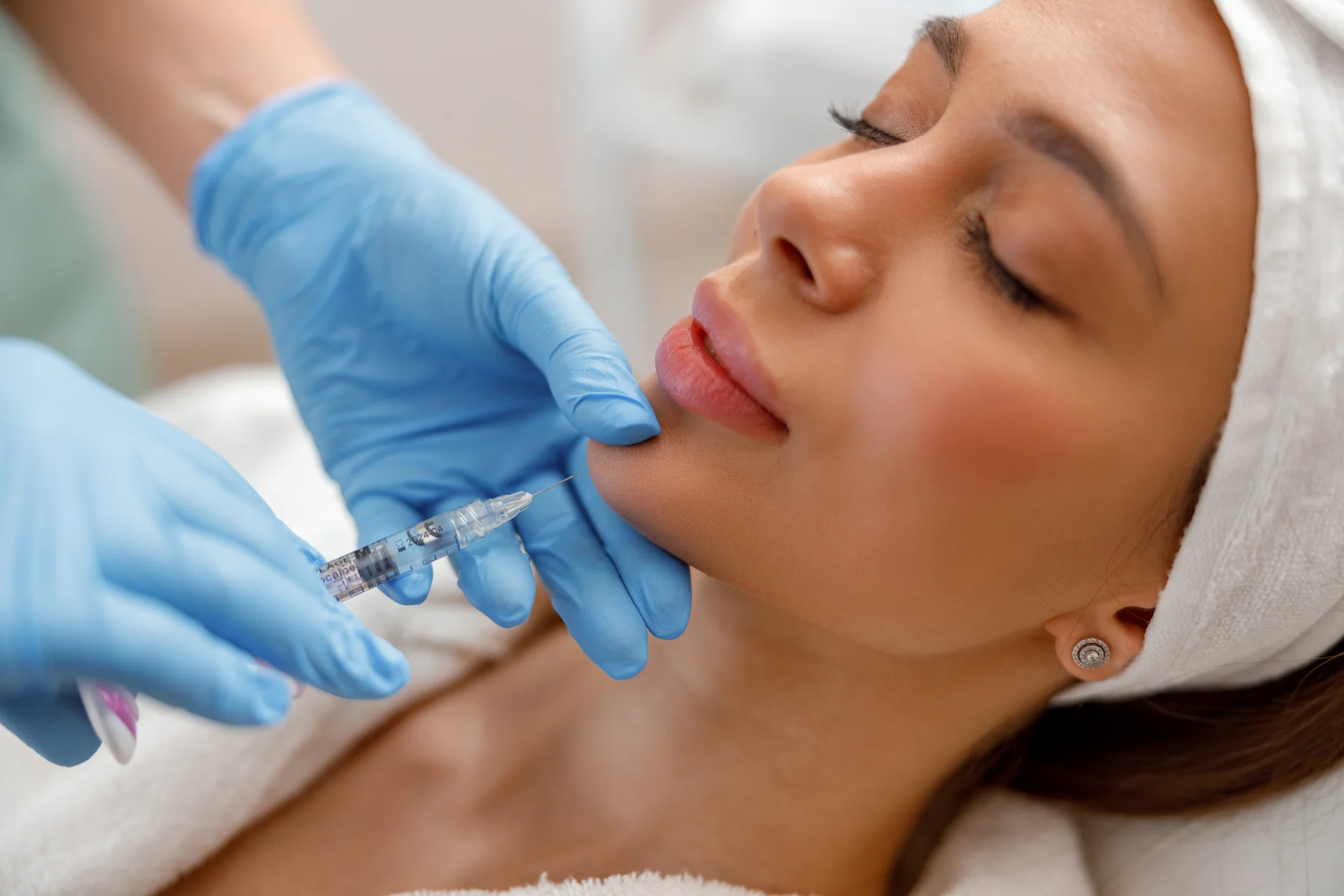 a woman having a chin filler injection at a beauty clinic||