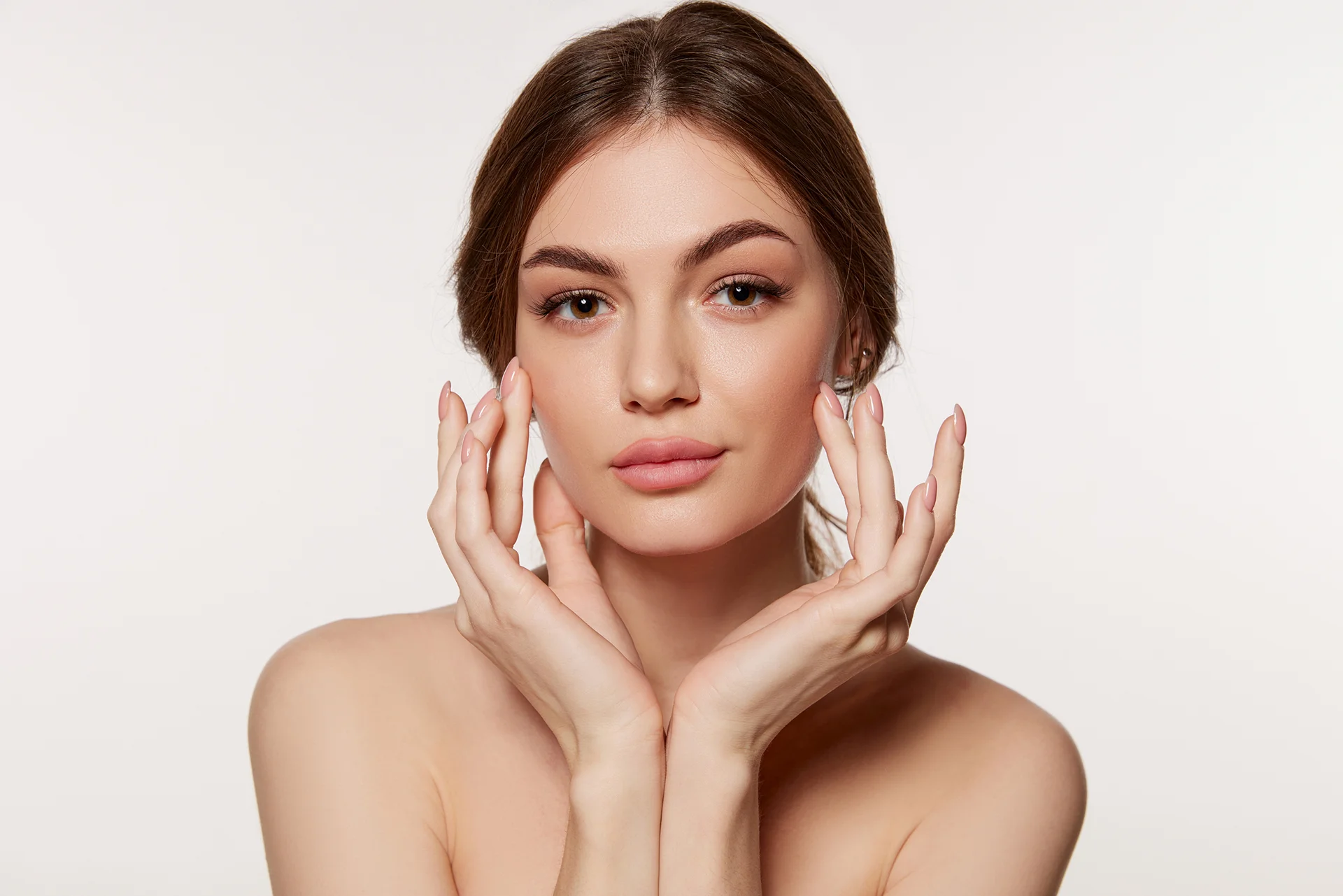 a woman touching her cheeks|cheek filler treatment|Dr. Lanna and her team