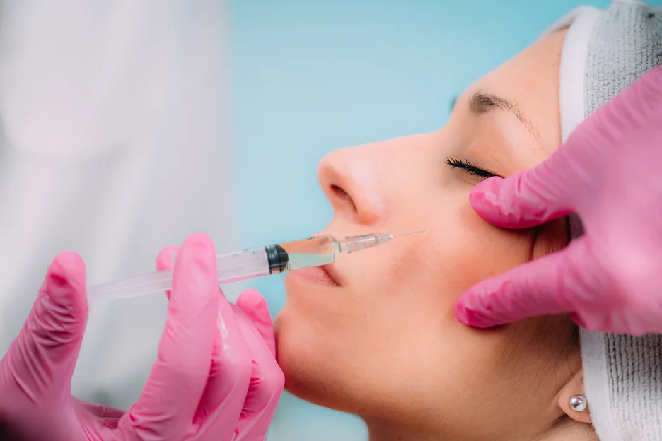 a woman receives dermal filler injection from her medical provider